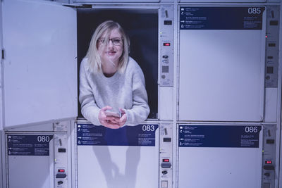 Portrait of young woman using in locker