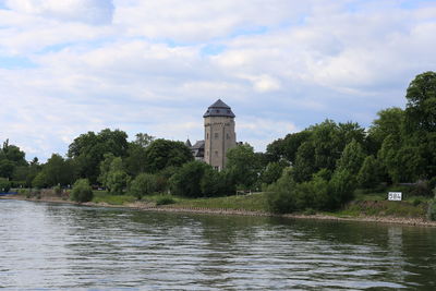 Scenic view of river by building against sky