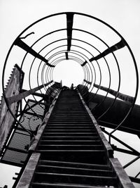 Low angle view of abandoned ladder against clear sky