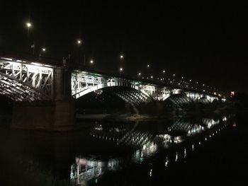 Illuminated bridge in city against sky at night