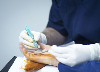 Midsection of doctor stitching hand