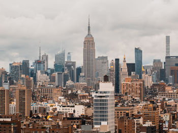 View of cityscape against cloudy sky