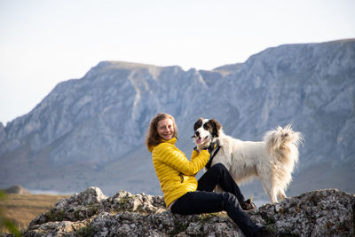 Man with dog sitting on rock