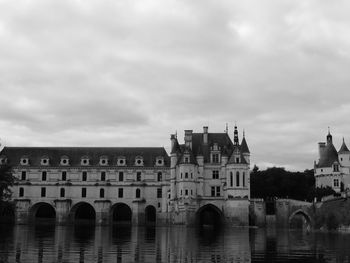 Arch bridge over river against buildings