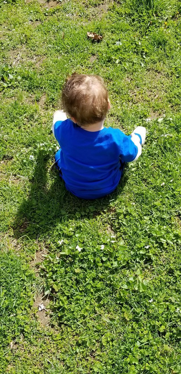 HIGH ANGLE VIEW OF BOY ON GRASS