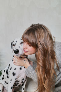 Side view of woman with dog on floor at home