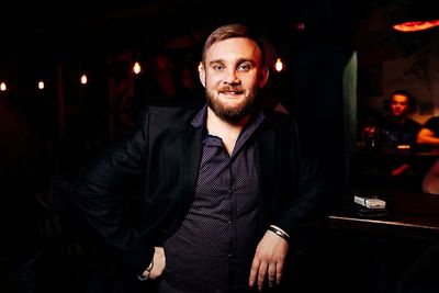 Portrait of smiling man standing by counter in darkroom