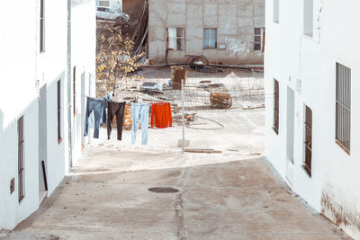 Clothes drying on footpath amidst buildings