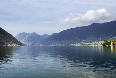 Scenic view of lake by mountains against sky