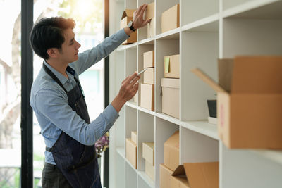 Side view of young woman standing in library