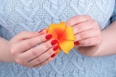 Midsection of woman holding yellow flower