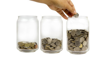 Close-up of hand holding jar against white background