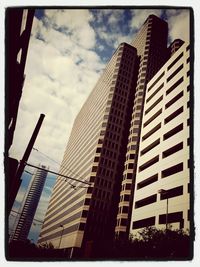 Low angle view of modern building against cloudy sky