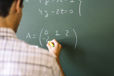 Math teacher solving problems on chalkboard