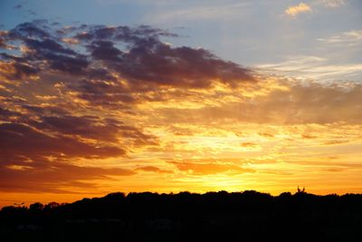 Scenic view of silhouette landscape against orange sky