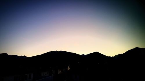 Silhouette mountains against clear sky during sunset