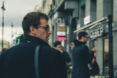 Young man looking at city street