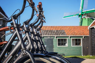 Bicycle parked outside house against blue sky