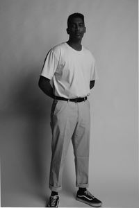 Portrait of young man standing against backdrop