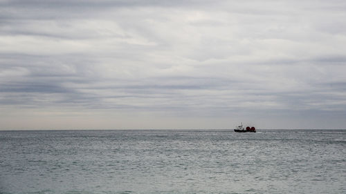 Boat sailing in sea against sky