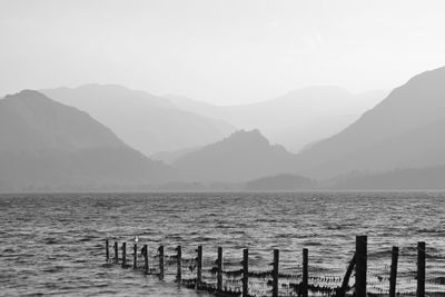 Scenic view of sea and mountains against clear sky