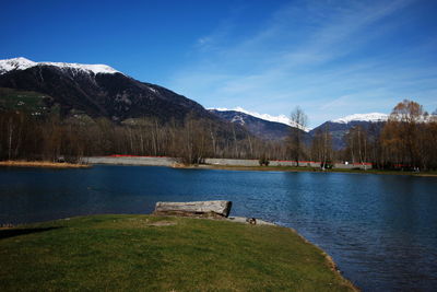 Scenic view of lake and mountains against blue sky