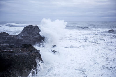 Waves splashing on rock formation at shore