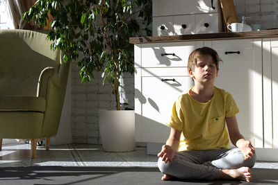 Little boy practicing yoga, stretching, fitness at home. distant online education training at home.