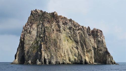 Rock formation and sea against sky