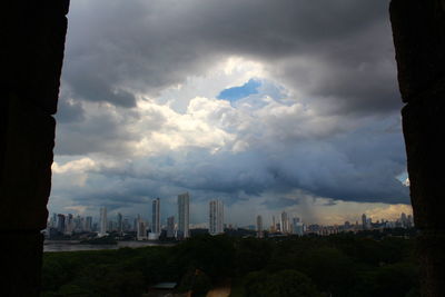 Buildings in city against cloudy sky