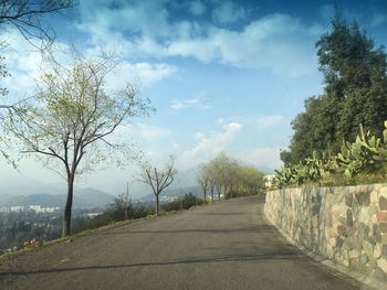 Road amidst trees against sky