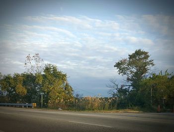 Empty road with trees in background
