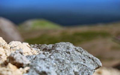 Close-up of rocks on mountain against sky