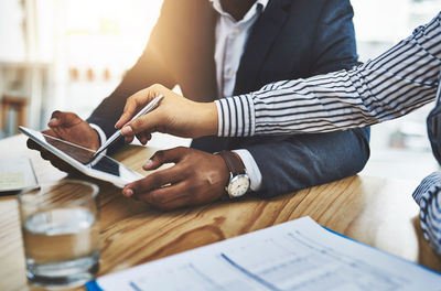 Midsection of business colleagues working on table