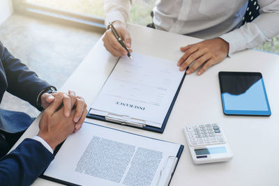 High angle view of businessmen doing paperwork in office