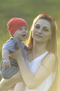 Portrait of happy mother carrying cute son