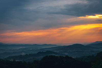 Scenic view of dramatic sky over mountains during sunset