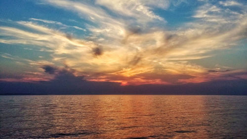 Scenic view of sea against dramatic sky during sunset