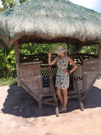 Full length of woman sitting on chair against plants