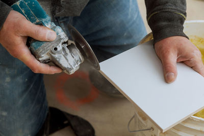 Midsection of carpenter working on wood at home