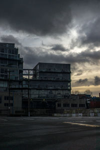 Buildings in city against cloudy sky