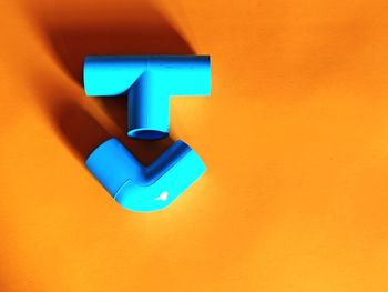 Close-up of illuminated lamp against orange wall