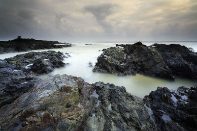 Scenic view of rocks in sea against sky