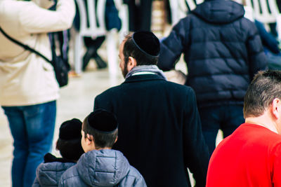 Rear view of men standing in city