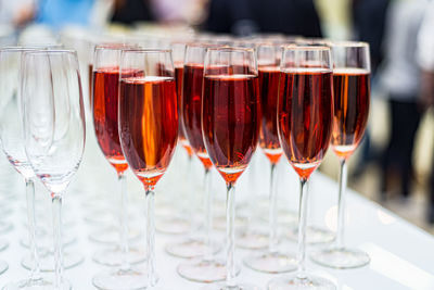 Champagne rose glasses on the bar. lots of glasses with drinks. 