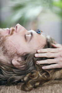 Close-up of man with closed eyes lying on sheet