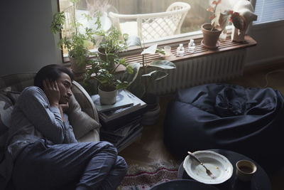 Sad man facing depression lying in bed