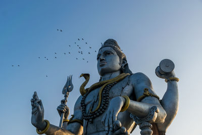 Low angle view of angel statue against sky