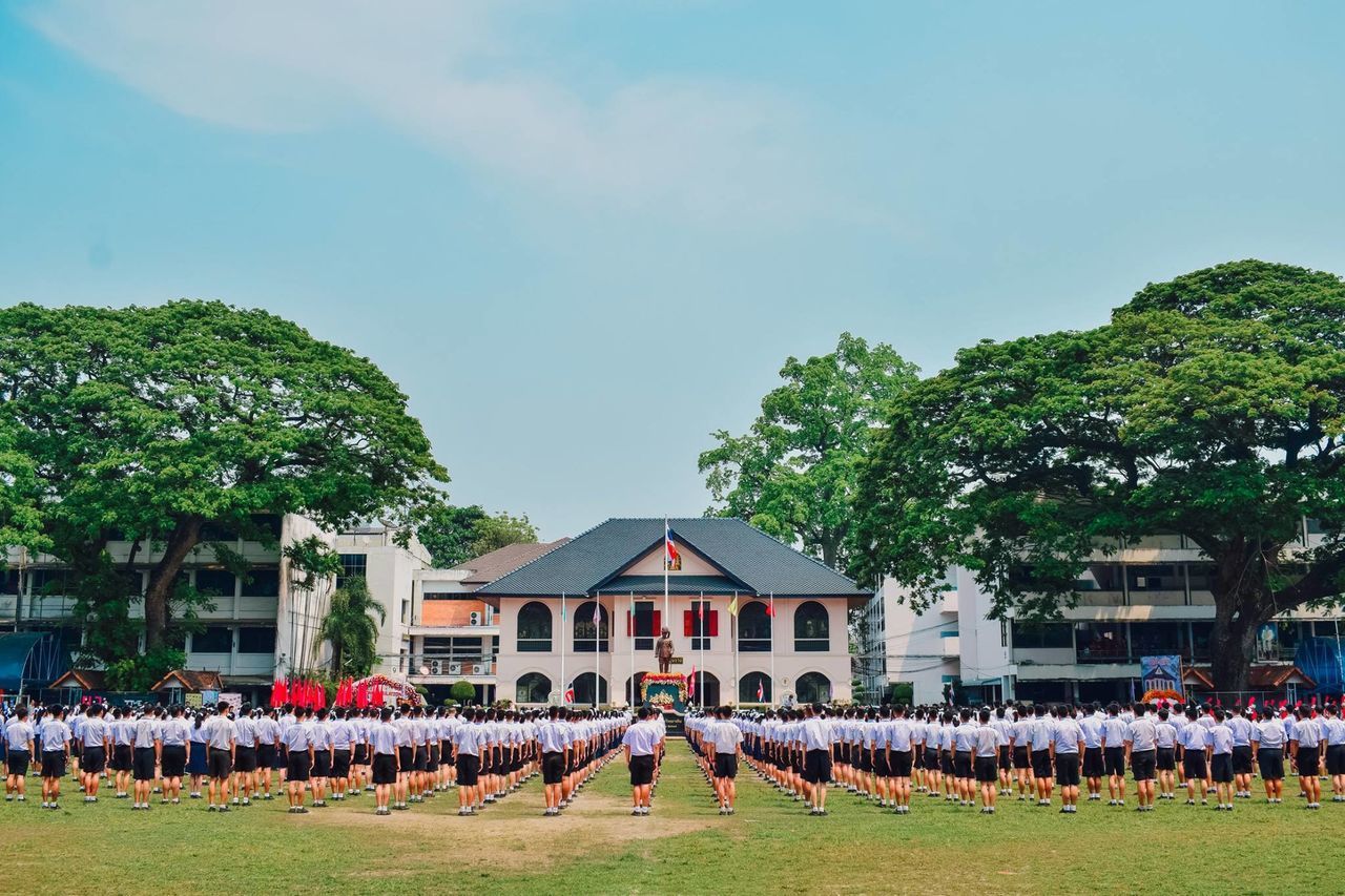 GROUP OF PEOPLE WALKING AGAINST BUILDING