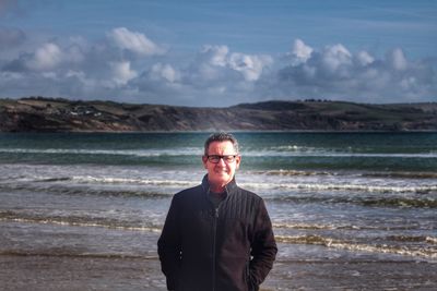 Man standing at beach against sky